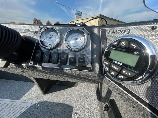 Slide: The Image of 2025 Lund 1650 Rebel XL SS dashboard with gauges and audio controls. - 8