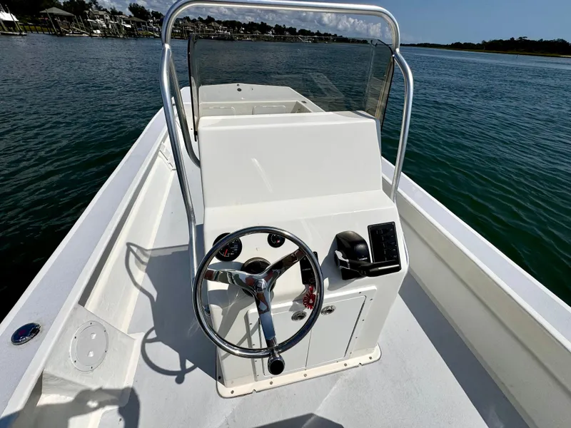 Slide: The Image of 2023 May-Craft 25 Hancock Skiff boat on calm water, featuring a sleek console design. - 10