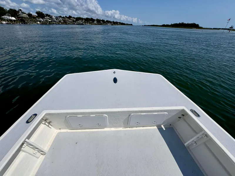 Slide: The Image of 2023 May-Craft 25 Hancock Skiff on calm water, clear sky, coastal view. - 6
