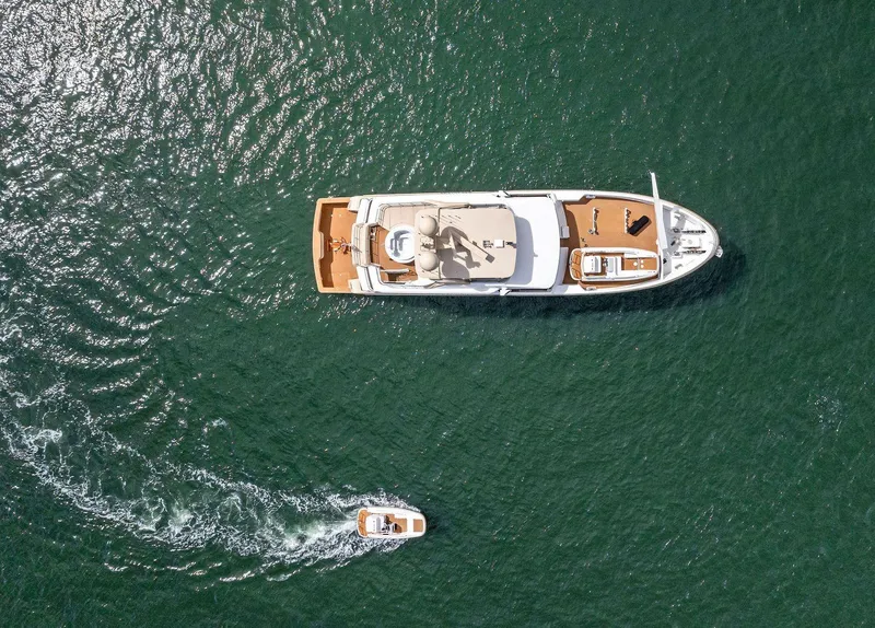 Slide: The Image of Aerial view of 2017 Burger 104 Motor Yacht cruising with a small boat nearby. - 14