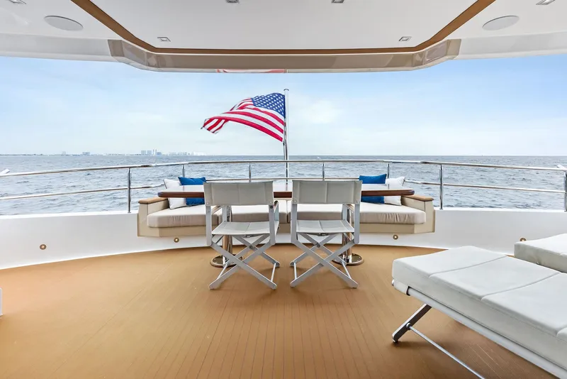 Slide: The Image of Luxurious 2017 Burger 104 Motor Yacht deck with seating, ocean view, and American flag. - 50