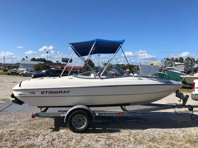 Slide: The Image of 2001 Stingray 180 LS/LX boat on trailer with blue canopy. - 24