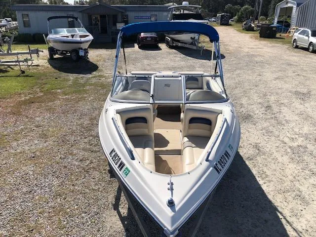 Slide: The Image of 2001 Stingray 180 LS/LX boat with blue canopy in a marina setting. - 8