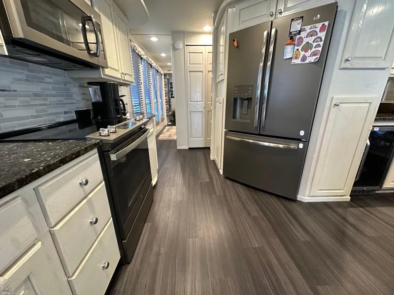 Slide: The Image of Modern kitchen in a 2001 Sharpe 16x80 houseboat with stainless steel appliances and sleek flooring. - 20
