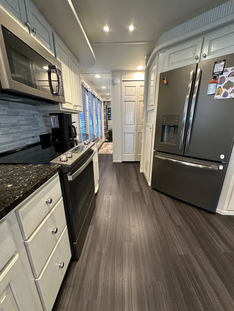 Slide: The Image of Modern kitchen in 2001 Sharpe 16x80 houseboat with stainless steel appliances and sleek flooring. - 21