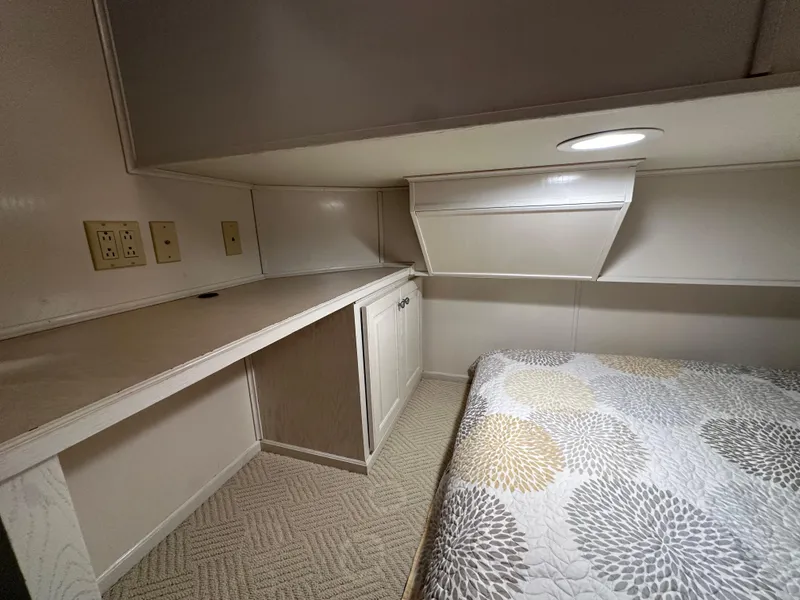 Slide: The Image of Compact bedroom in 2001 Sharpe 16x80 houseboat with bed, desk, and storage. - 27