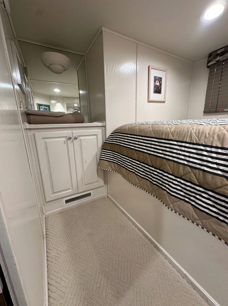 Slide: The Image of Cozy bedroom interior in 2001 Sharpe 16x80 houseboat with striped bedding and mirrored cabinet. - 32