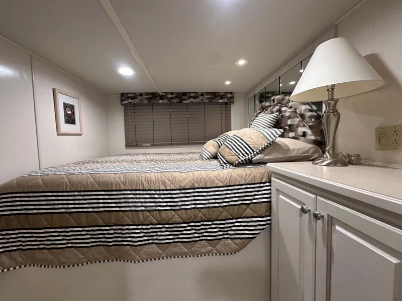 Slide: The Image of Cozy bedroom in 2001 Sharpe 16x80 houseboat with striped bedding and lamp. - 34