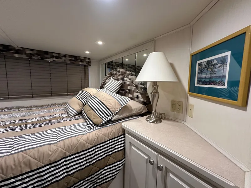 Slide: The Image of Cozy bedroom in 2001 Sharpe 16x80 houseboat with striped bedding and lamp. - 35