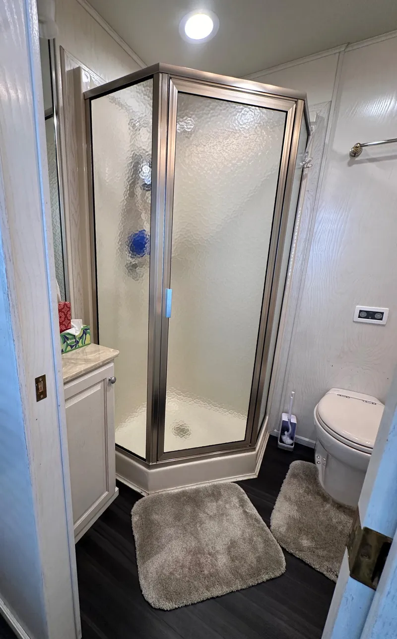 Slide: The Image of Compact bathroom with glass shower, toilet, and vanity in a 2001 Sharpe 16x80 model. - 38