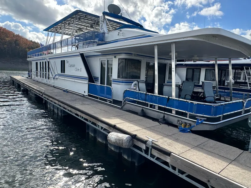 Slide: The Image of Houseboat docked on a lake, Sharpe 16x80 model, 2001, with blue and white exterior. - 4