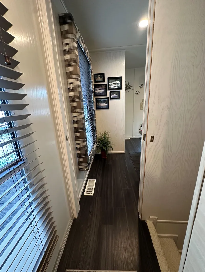 Slide: The Image of Narrow hallway in 2001 Sharpe 16x80 houseboat with wood flooring and wall decor. - 42