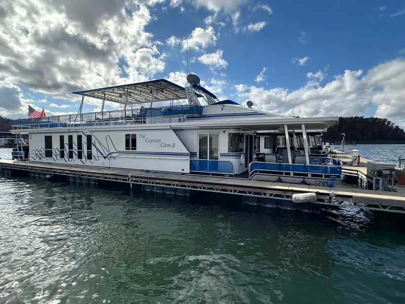 Slide: The Image of 2001 Sharpe 16x80 houseboat docked on a sunny day with American flag. - 5