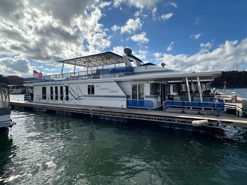 Slide: The Image of 2001 Sharpe 16x80 houseboat docked on a sunny day with American flag. - 7
