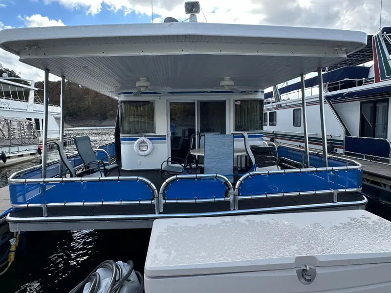 Slide: The Image of 2001 Sharpe 16x80 houseboat with blue accents docked at marina. - 8