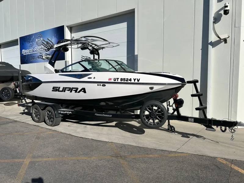 Slide: The Image of 2015 Supra SC400-550 boat on trailer outside marine dealership. - 1