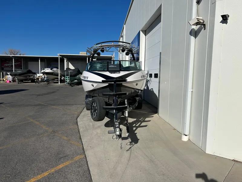 Slide: The Image of 2015 Supra SC400-550 boat parked outside a garage on a sunny day. - 2