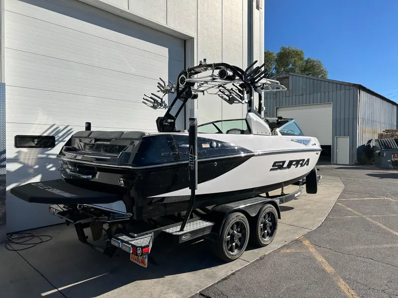 Slide: The Image of 2015 Supra SC400-550 boat on trailer, parked outside industrial building. - 3