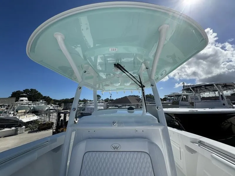 Slide: The Image of 2025 Southport 30 FE boat with T-top, docked under a sunny sky. - 15