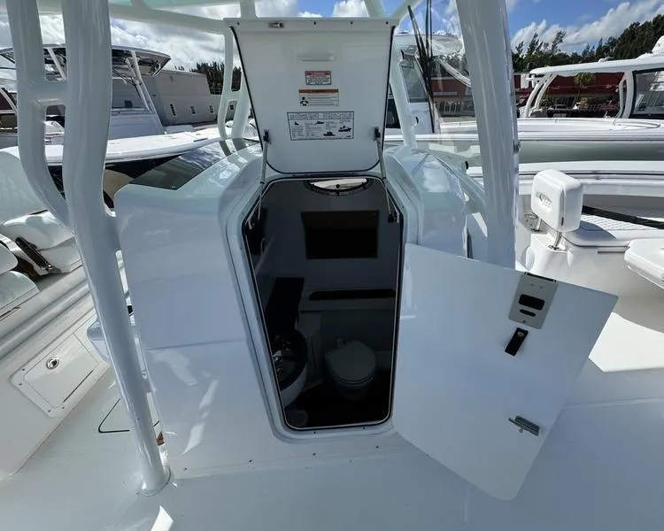 Slide: The Image of 2025 Southport 30 FE boat interior cabin with open door, showcasing compact design. - 16