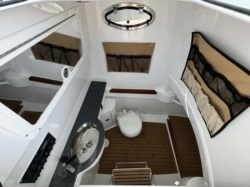 Slide: The Image of 2025 Southport 30 FE boat interior with sink, toilet, and wood flooring. - 17