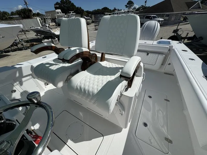Slide: The Image of 2025 Southport 30 FE boat interior with luxurious white seating and steering wheel. - 24