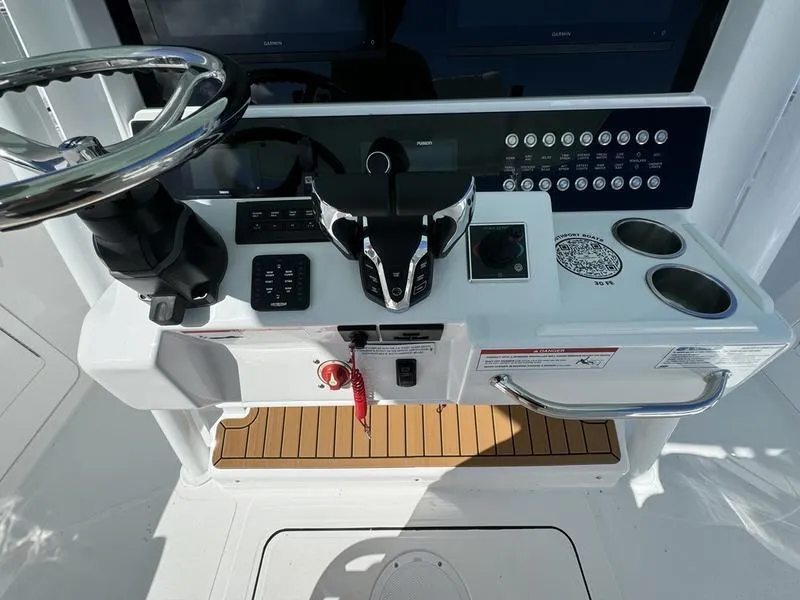 Slide: The Image of 2025 Southport 30 FE boat helm with steering wheel and control panel. - 30