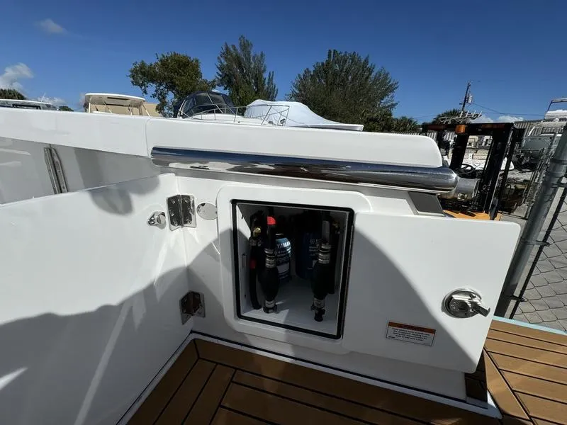 Slide: The Image of 2025 Southport 30 FE boat with open storage compartment, docked outdoors. - 43