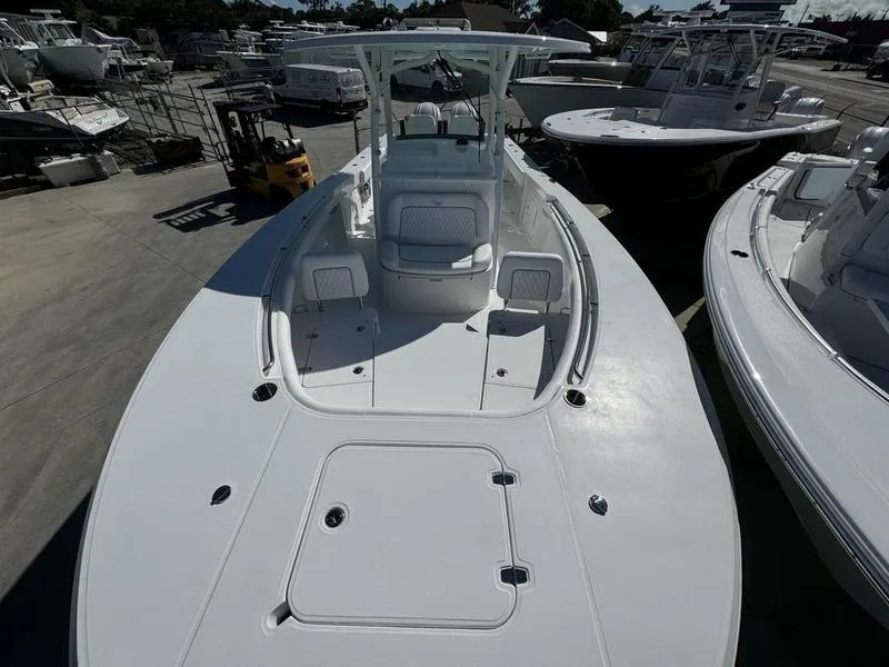 Slide: The Image of 2025 Southport 30 FE boat, docked, showcasing spacious deck and seating area. - 7