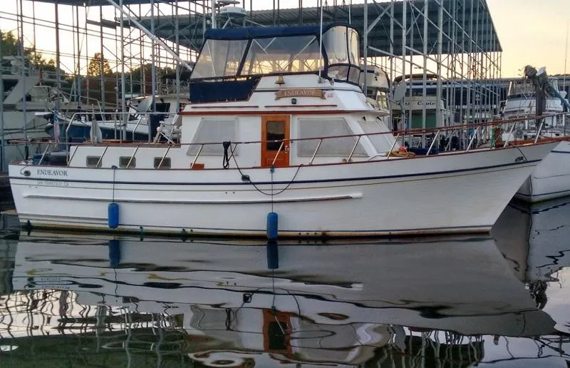 Slide: The Image of 1983 DeFever 41 Trawler docked at marina, reflecting on calm water. - 1