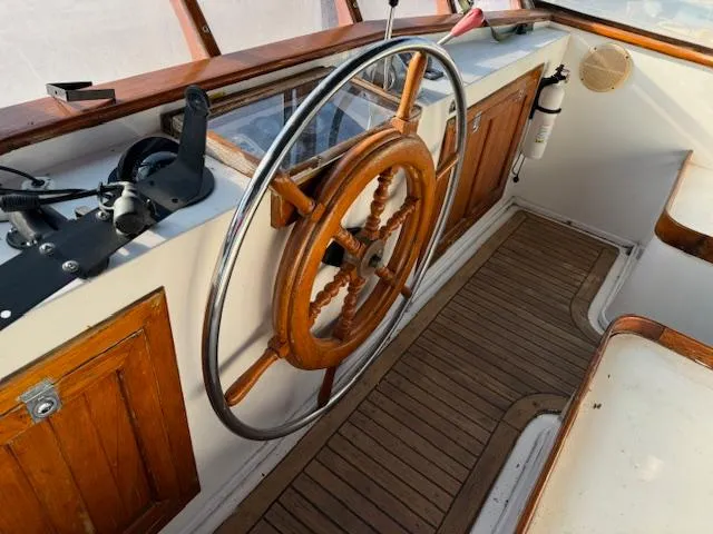Slide: The Image of 1983 DeFever 41 Trawler helm with wooden wheel and classic nautical design. - 10