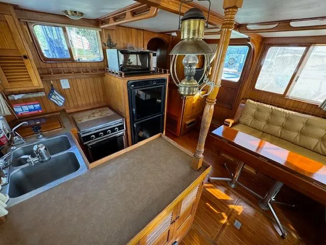 Slide: The Image of Interior of 1983 DeFever 41 Trawler with wood finish, kitchen, and seating area. - 20