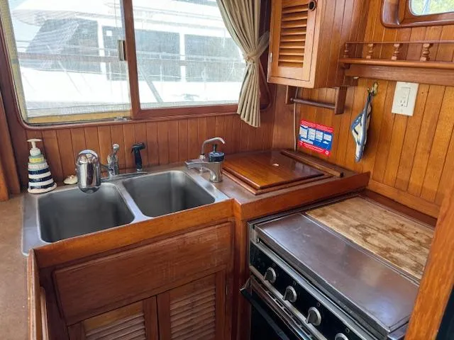 Slide: The Image of 1983 DeFever 41 Trawler kitchen with wooden cabinetry, double sink, and stove. - 22