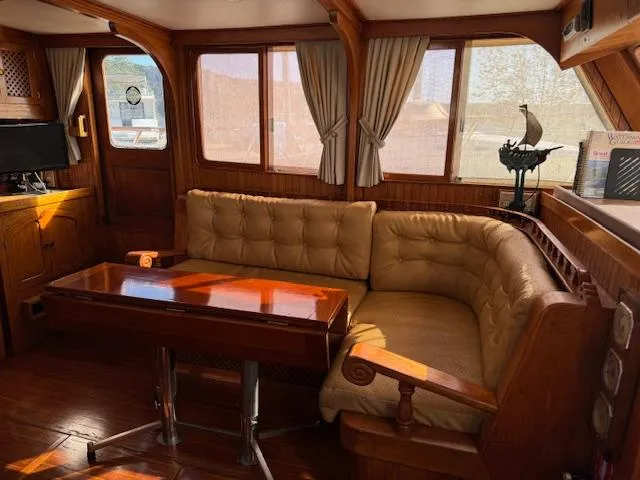 Slide: The Image of Interior of 1983 DeFever 41 Trawler with wooden furnishings and beige seating. - 28