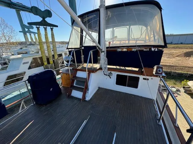 Slide: The Image of 1983 DeFever 41 Trawler deck with seating and helm station, docked at marina. - 4