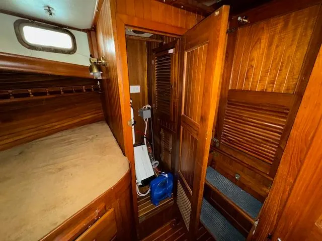 Slide: The Image of 1983 DeFever 41 Trawler cabin interior with wooden paneling and storage. - 44