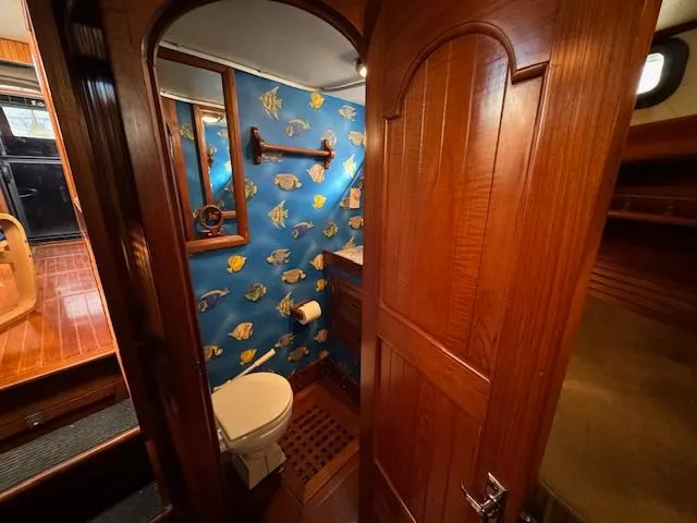 Slide: The Image of 1983 DeFever 41 Trawler bathroom with nautical-themed wallpaper and wooden interior. - 46