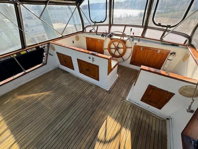 Slide: The Image of 1983 DeFever 41 Trawler helm with wooden wheel and spacious deck. - 6