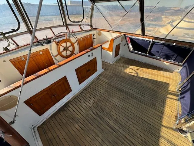 Slide: The Image of 1983 DeFever 41 Trawler helm with wooden wheel and spacious deck. - 7