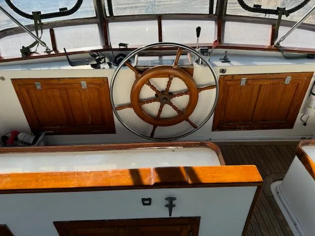 Slide: The Image of 1983 DeFever 41 Trawler helm with wooden wheel and classic controls. - 9