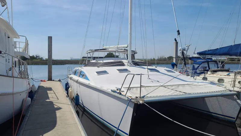 The Image of 1999 PDQ 36 catamaran docked at marina under clear blue sky. - 1