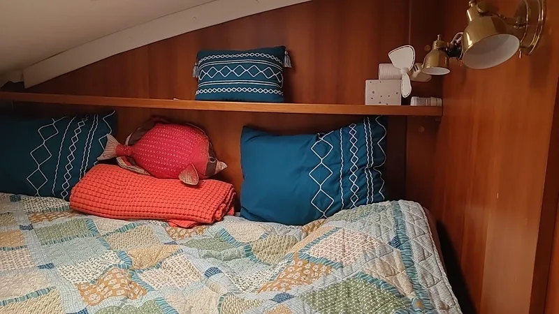 Slide: The Image of Cozy cabin bed with colorful quilt and pillows in a 1999 PDQ 36 boat. - 11