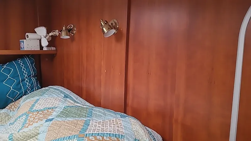 Slide: The Image of Cozy cabin interior with quilted bedding and wooden walls, PDQ 36, 1999 model. - 12