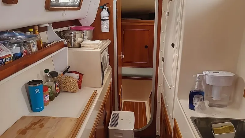 Slide: The Image of Compact galley kitchen in a 1999 PDQ 36 boat with wooden cabinetry and appliances. - 15