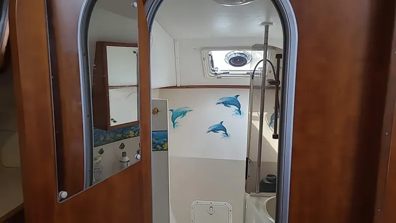 Slide: The Image of Interior of 1999 PDQ 36 boat with dolphin wall art and wooden finishes. - 16