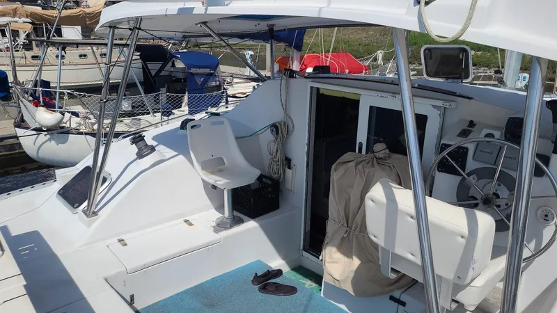 Slide: The Image of 1999 PDQ 36 catamaran cockpit with steering wheel, seating, and marina view. - 4