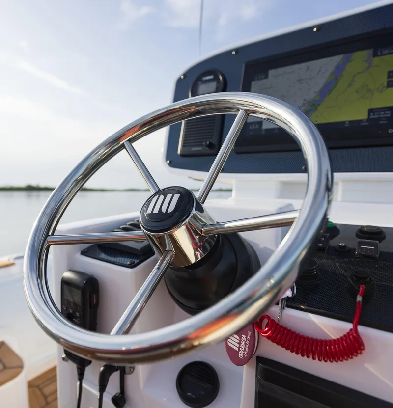 Slide: The Image of Steering wheel and dashboard of 2025 Novurania Catamaran 24, featuring navigation display. - 6