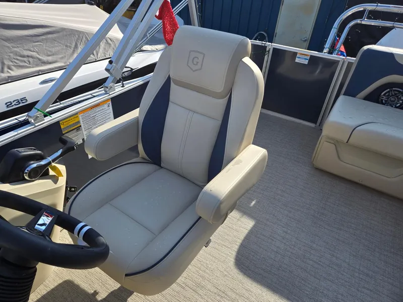 Slide: The Image of 2025 Godfrey Sweetwater 2086 C boat interior with beige captain's chair and steering wheel. - 13