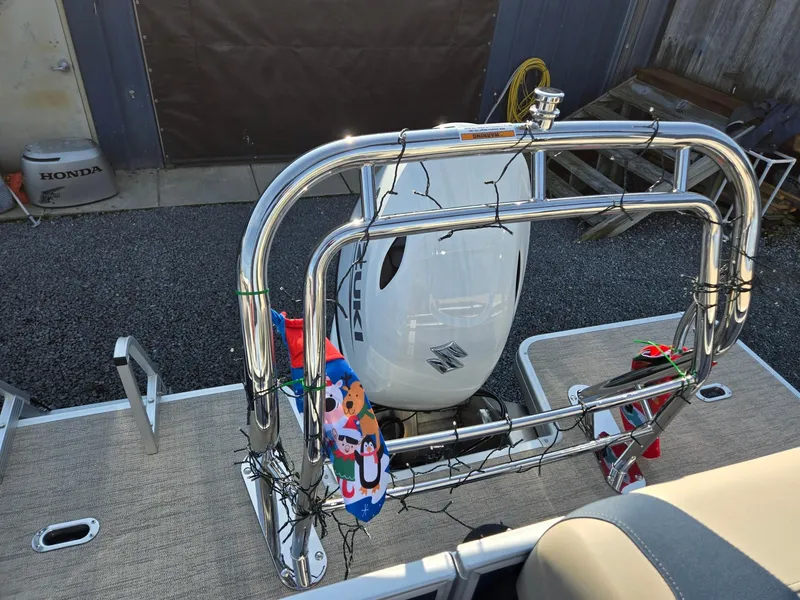 Slide: The Image of 2025 Godfrey Sweetwater 2086 C boat with Suzuki outboard motor, decorated with festive lights. - 22