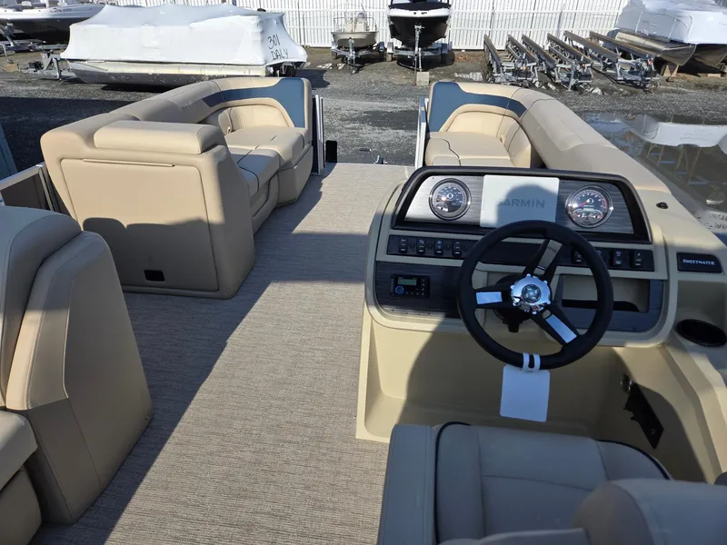 Slide: The Image of 2025 Godfrey Sweetwater 2086 C pontoon boat interior with beige seating and steering console. - 25
